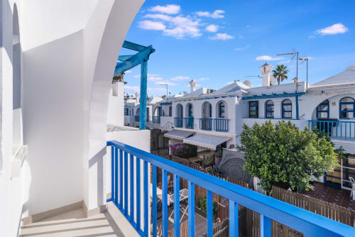 Balcón de la bungalow Flor del Almendro con barandilla azul con vistas a edificios encalados en Maspalomas, Gran Canaria