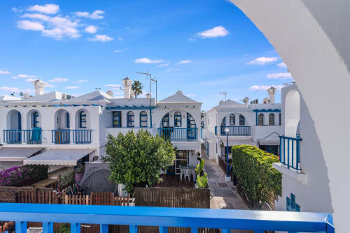 Bungalós estilo mediterráneo en azul y blanco con terrazas en Maspalomas, Gran Canaria, con vistas al jardín