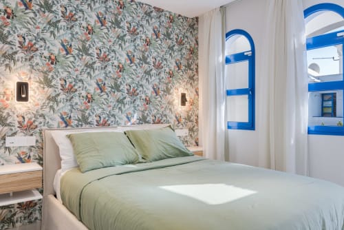 Dormitorio luminoso en bungaló Flor del Almendro, Home Stay Gran Canaria, con papel tapiz tropical, ropa de cama verde y azul