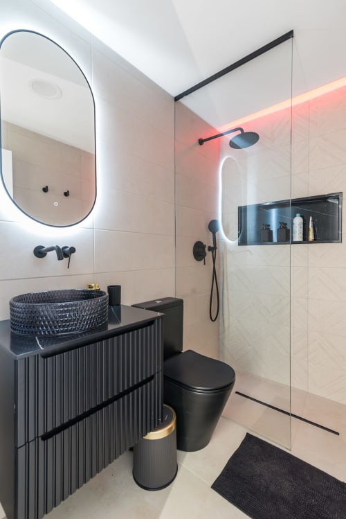 Baño moderno en bungalow Flor del Almendro, Maspalomas, con accesorios negros y ducha de efecto lluvia