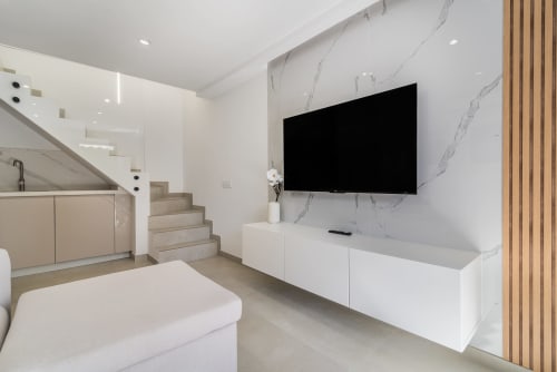 Sala moderna en Bungalow Flor del Almendro, Maspalomas con televisor de pared, pared de mármol y diseño contemporáneo