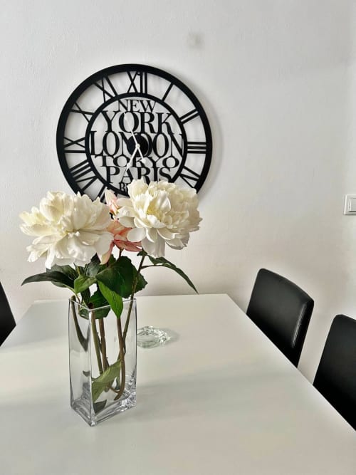 Elegante interior de apartamento en Fuengirola con peonías blancas, jarrón de cristal, reloj mundial negro y decoración moderna