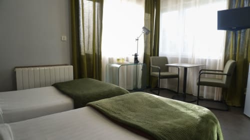 Chambre twin studio à l'hôtel Cosyade à Bourbourg avec lits jumeaux, vue sur jardin et équipements modernes