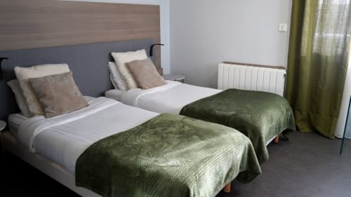 Lits jumeaux avec couvertures vertes à Studio 1 de l'hôtel Cosyade, Bourbourg, France