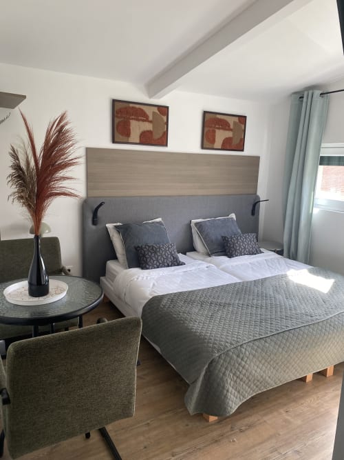 Chambre studio moderne à l'hôtel Cosyade à Bourbourg avec lit queen-size, vue sur le jardin et décoration contemporaine