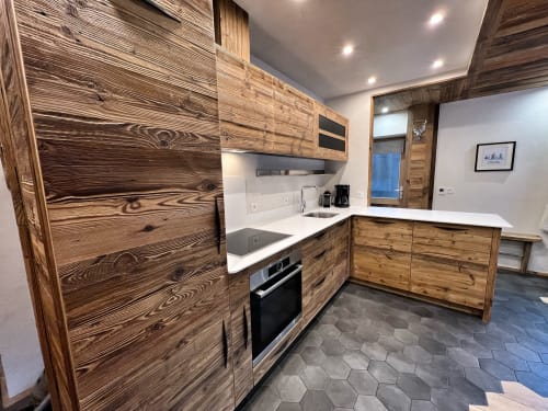 Modern kitchen with wooden cabinetry, white countertops, and stainless steel appliances in Appartement Alba at Chez Francine,