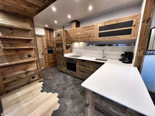 Modern kitchen in Chez Francine apartment with wooden cabinetry, white countertops, and hexagonal tile flooring