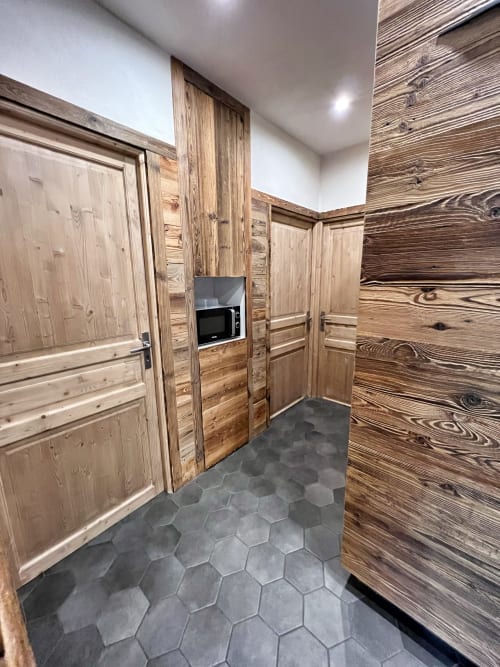 Modern hallway with wooden cabinetry and dark hexagonal tile flooring at Chez Francine apartment, Notre-Dame-de-Bellecombe