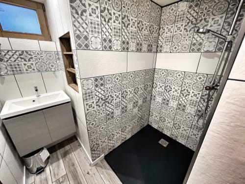 Modern bathroom shower with patterned tiles at Chez Francine apartment, Notre-Dame-de-Bellecombe