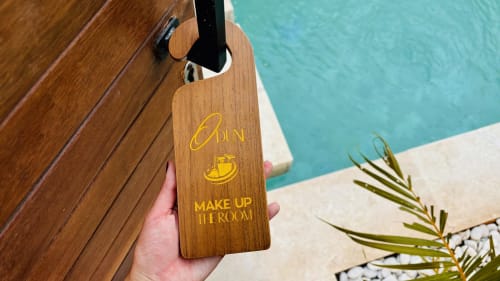 Wooden door hanger with 'Run Make Up In Room' text at Oasis Dune Villas, Lombok, with turquoise pool in background