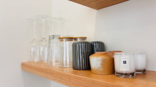 Wooden shelf displaying decorative items, candles, and storage containers at Oasis Dune Villas villa in Lombok