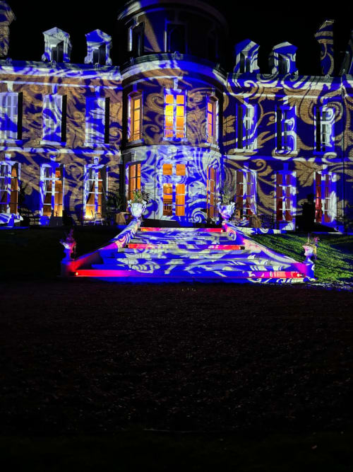 Château Du Landin illuminated at night with blue and gold projection mapping on historic stone façade