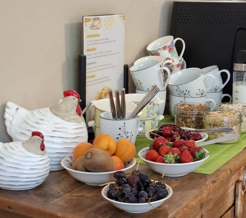 Petit-déjeuner copieux au Mas des Vergers avec fruits frais, baies, céréales et vaisselle à motifs floraux
