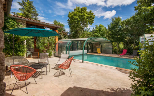 Villa avec piscine privée à Millau : bassin eau salée turquoise, couverture rétractable, transats, parasol et jardin luxuriant