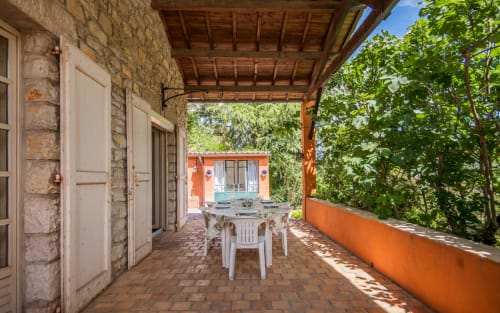 Patio couvert avec table à manger de la villa Casa de la huerta à Millau, vue sur le jardin et la piscine