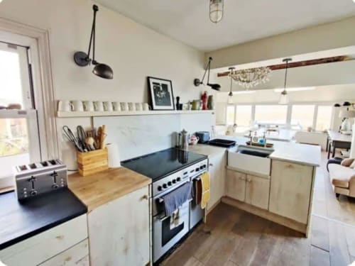 Bright modern kitchen at 2 Doves Holiday Property, Exeter, featuring stainless steel range cooker and white cabinetry