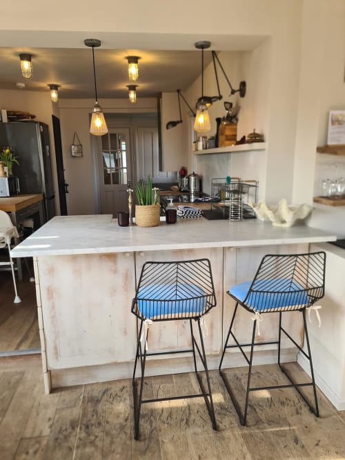 Modern kitchen island with blue bar stools, pendant lights, and stainless steel appliances at 2 Doves Holiday Property,