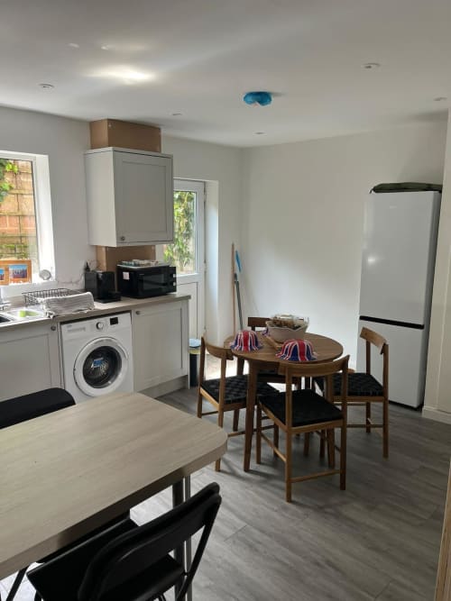 Modern kitchen and dining area at 2 Doves Holiday Property in Exeter with white appliances and wooden table