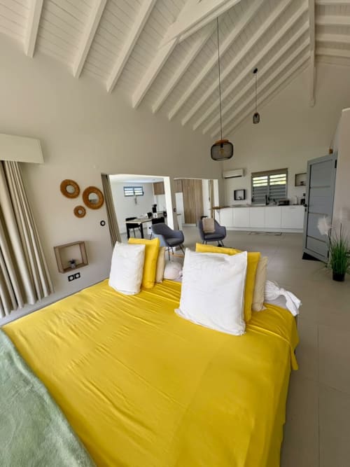 Lit jaune éclatant dans l'appartement moderne Le LOFT 5 ESMEE à Maly Blue Location, Guadeloupe avec vue mer et design contemporain