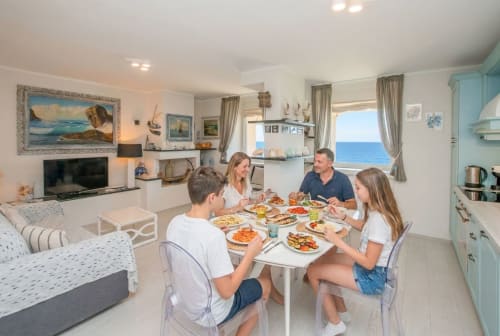 Famiglia che cena nell'appartamento Ancora di Welcome Varigotti con vista mare, sulla costiera ligure italiana