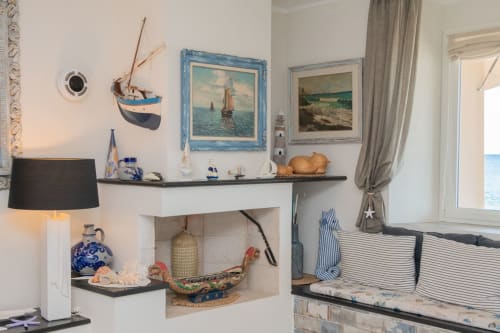 Appartamento a tema nautico con vista sul mare, arredato con opere d'arte marittima, modello di barca a vela e arredi costieri
