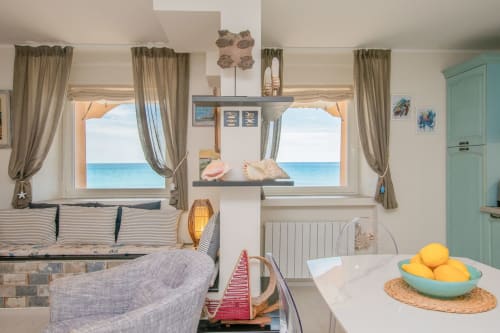 Luminoso appartamento con vista mare al Welcome Varigotti, accenti turchesi, arredamento costiero e finestre panoramiche sul mare