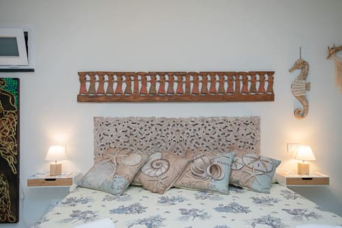 Camera con testiera scolpita ornamentale, cuscini decorativi e decor marino con cavalluccio nell'appartamento Ancora, Varigotti