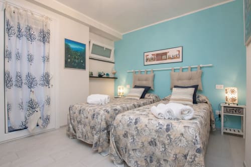 Letti gemelli in camera da letto azzurra luminosa presso Welcome Varigotti, appartamento Ancora con vista mare e comfort moderni