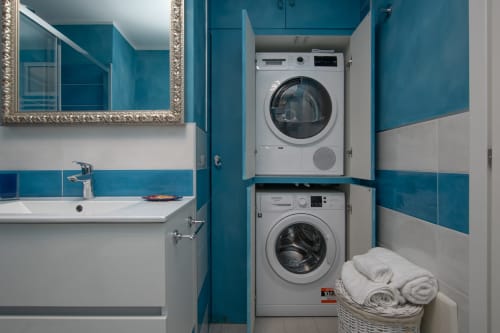 Bagno moderno con lavatrice e asciugatrice impilate nell'appartamento Welcome Varigotti, camera Ancora, Varigotti