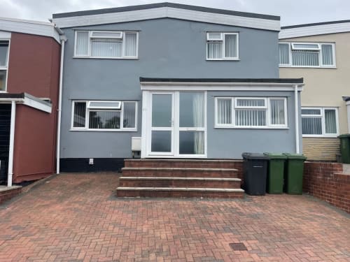 2 Doves Holiday Property in Exeter, modern blue house with brick driveway and white windows