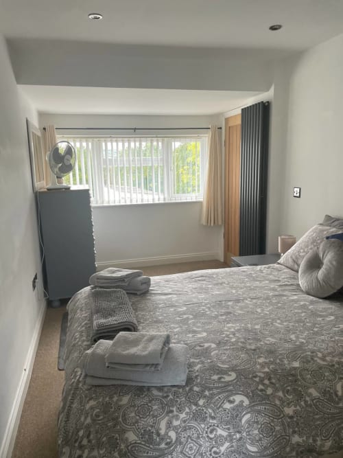 Modern bedroom at 2 Doves Holiday Property, Exeter with double bed, large windows, vertical blinds and contemporary