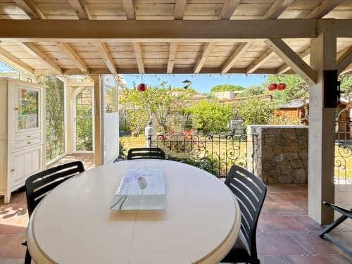Terrasse avec vue sur le jardin à la Villa Marine de Sant Ambroggio à L'Île-Rousse, table à manger et pergola en bois