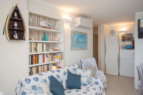 Accogliente appartamento con vista mare a Welcome Varigotti, arredamento nautico, scaffale a forma di barca, biancheria oceano-tematica e design moderno