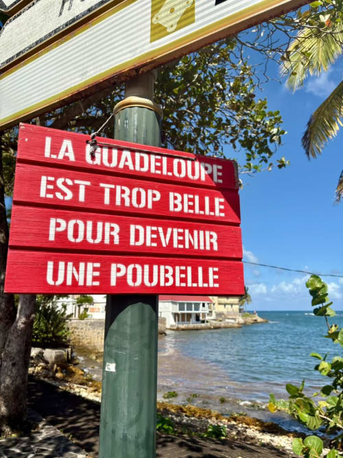 Panneau rouge français au Maly Blue Location à Le Moule, Guadeloupe, avec vue océan et végétation tropicale