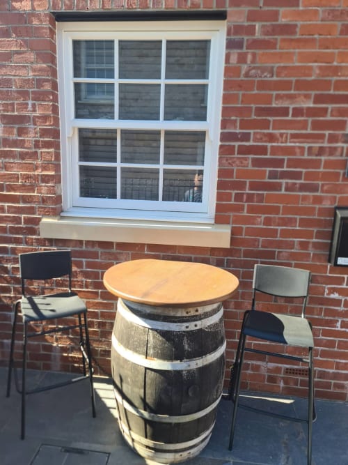 Barrel table with wooden top and two chairs on patio at 2 Doves Holiday Property, Exeter