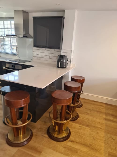 Modern kitchen at 2 Doves Holiday Property in Exeter with white countertop, bar stools, and stainless steel appliances