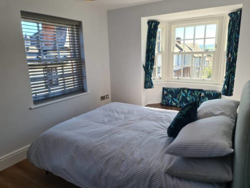 Bright bedroom at 2 Doves Holiday Property in Exeter with double bed, large bay window, coastal views, and teal patterned