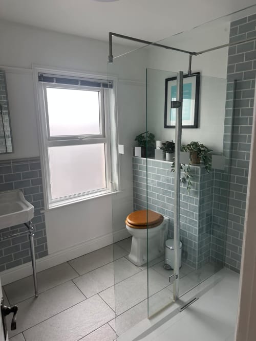 Modern bathroom at 2 Doves Holiday Property, Exeter with glass shower enclosure and green subway tiles