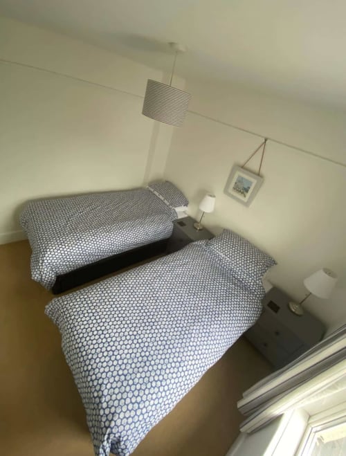 Twin bedroom at 2 Doves Holiday Property in Exeter with patterned bedding and side tables