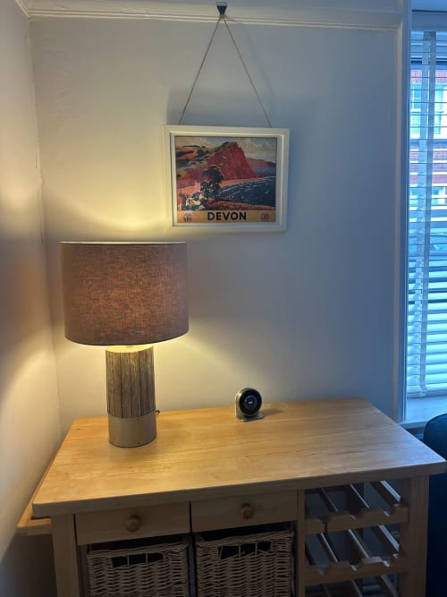 Wooden desk with linen lampshade and Devon travel poster in 2 Doves Holiday Property, Exeter