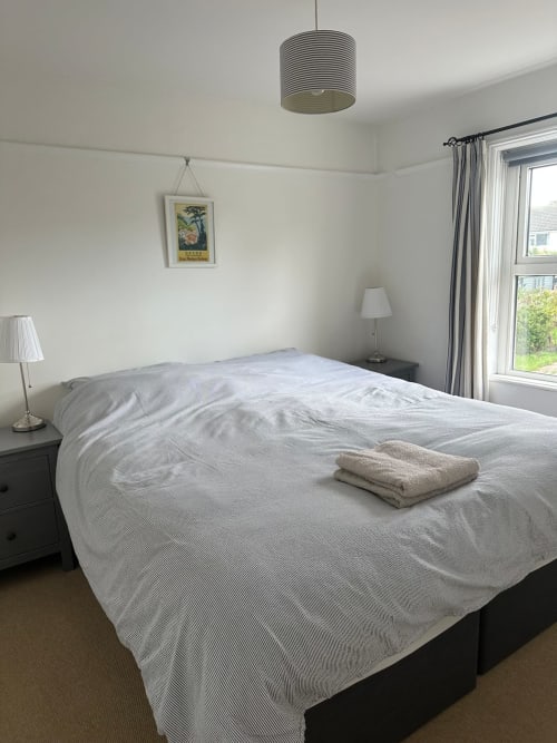 Bright modern bedroom at 2 Doves Holiday Property, Exeter, with double bed, pendant light, and garden views