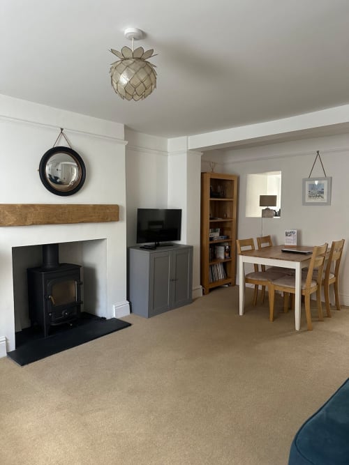 Spacious living area at 2 Doves Holiday Property in Exeter with fireplace, dining table, and modern furnishings