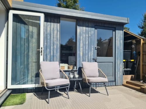 Modern garden room at 2 Doves Holiday Property, Exeter with comfortable seating and large windows