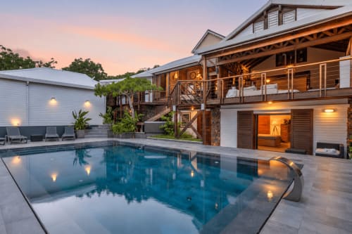 Villa de luxe avec piscine privée au coucher du soleil, station balnéaire Saint-Martin avec terrasse en bois, terrasse illuminée et design moderne