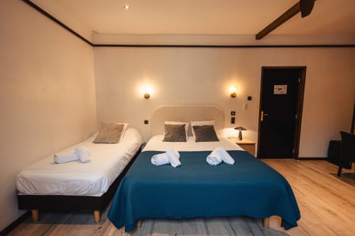 Chambre familiale du Savoy Hôtel au Bourget-du-Lac avec lits jumeaux et lit double, éclairage moderne et parquet