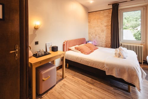 Chambre triple lumineuse au Savoy Hôtel avec tête de lit rayée, bureau, vue montagne et parquet à Le
