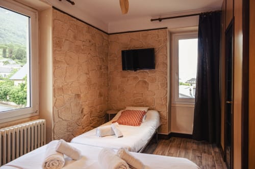 Chambre triple au Savoy Hôtel du Bourget-du-Lac avec lits jumeaux, murs en liège, TV écran plat et vue sur les montagnes