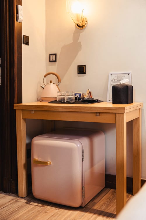 Bureau en bois avec mini-réfrigérateur rose et bouilloire à l'hôtel Savoy Le Bourget-du-Lac