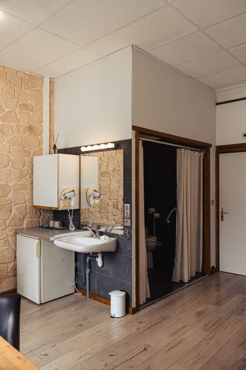 Salle de bain moderne de l'Hôtel Savoy avec lavabo, miroir et douche à Le Bourget-du-Lac