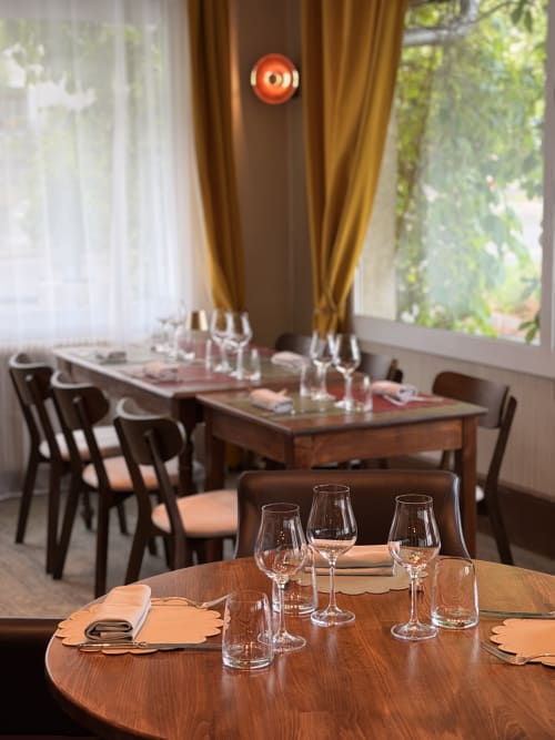 Salle à manger élégante du Savoy Hôtel avec table ronde en bois, verres à vin et chaises en cuir marron surplombant